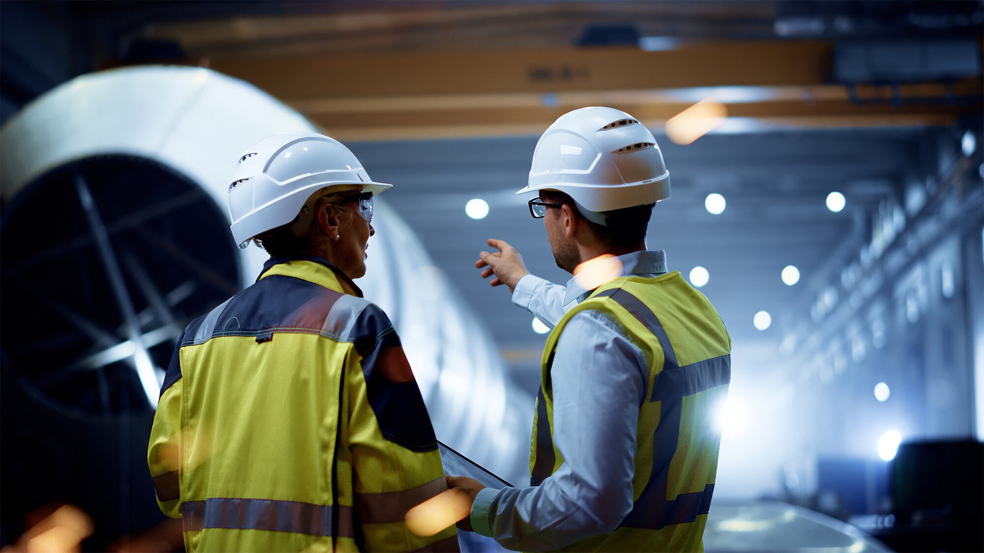 man pointing to heat exchanger talking about maintenance